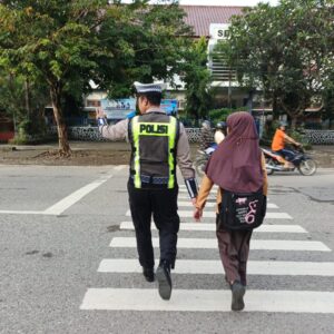 Sat Lantas Polres Bima Kota Bantu Seberangkan Pejalan Kaki dan Anak Sekolah, Ciptakan Kamseltibcarlantas yang Lancar