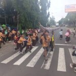 Personel Polsek Suela Atur Lalu Lintas di Depan SDN 02 Suela, Bantu Pelajar Menyeberang