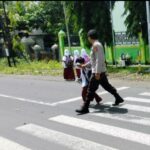 Personel Polsek Suela Laksanakan Pengaturan Lalu Lintas di Depan SDN 2 Suela untuk Tingkatkan Keamanan