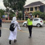 Polsek Rasanae Barat Laksanakan Rawan Pagi, Bantu Pelajar Menyeberang Jalan