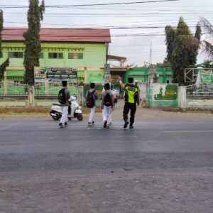 Bhabinkamtibmas Pringgabaya Gelar Strong Point Pagi, Bantu Siswa Menyeberang Jalan