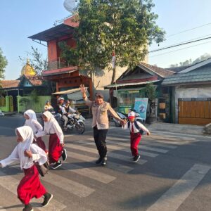 Polsek Rastim Bantu Seberangkan Anak Sekolah, Arus Lalu Lintas Tetap Lancar