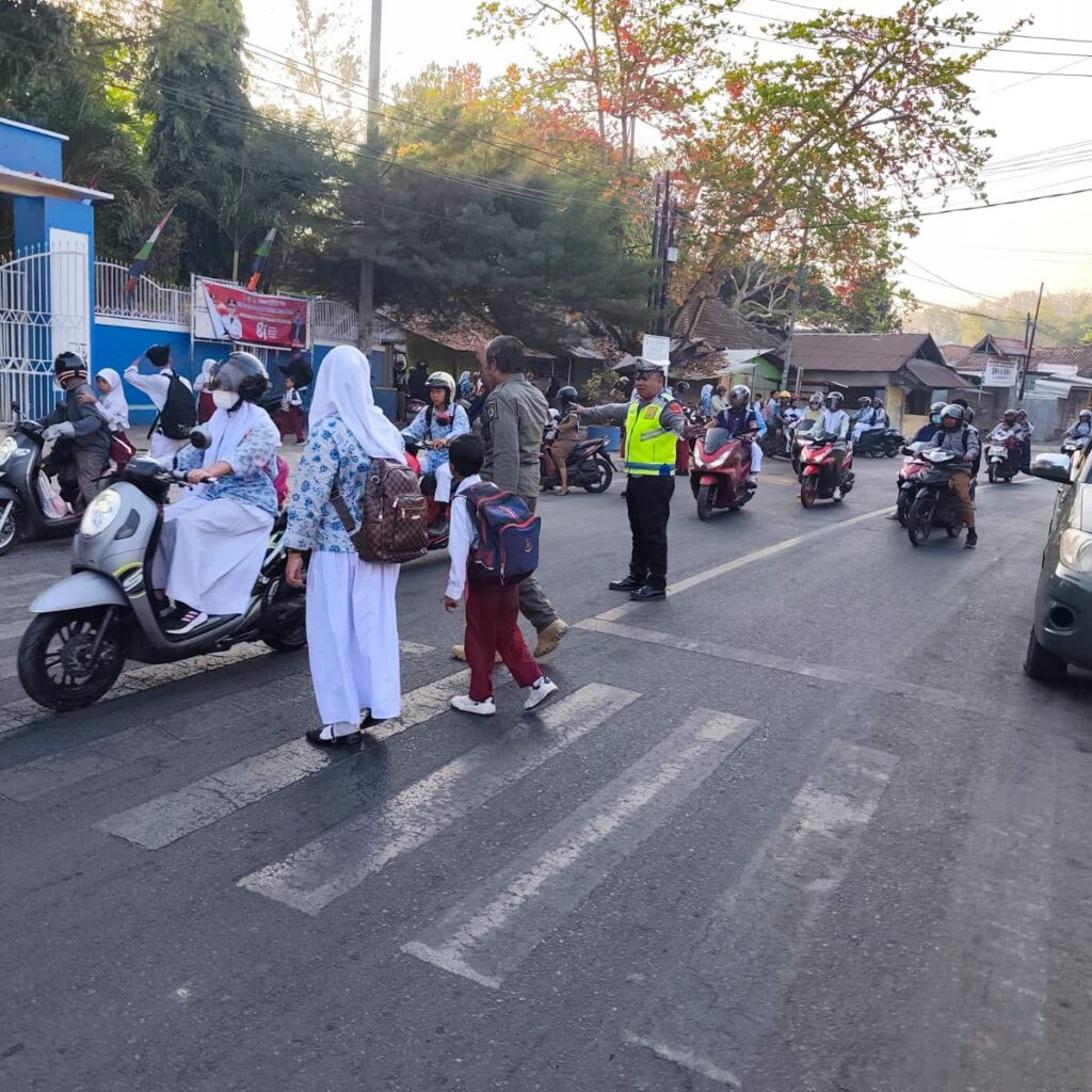 Berikan Rasa Aman, Sat Lantas Polres Bima Kota Bantu Pelajar Menyeberang di Jam Sibuk Pagi