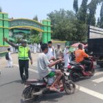 Unit Lantas Polsek Rasanae Barat Laksanakan Rawan Siang, Bantu Pelajar Menyebrang Jalan